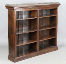 An Edwardian walnut two-section open bookcase with a brass three-quarter gallery, on a plinth