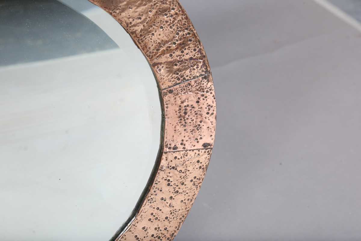 An early 20th century Arts and Crafts hammered copper oval wall mirror with riveted panels and - Image 3 of 6