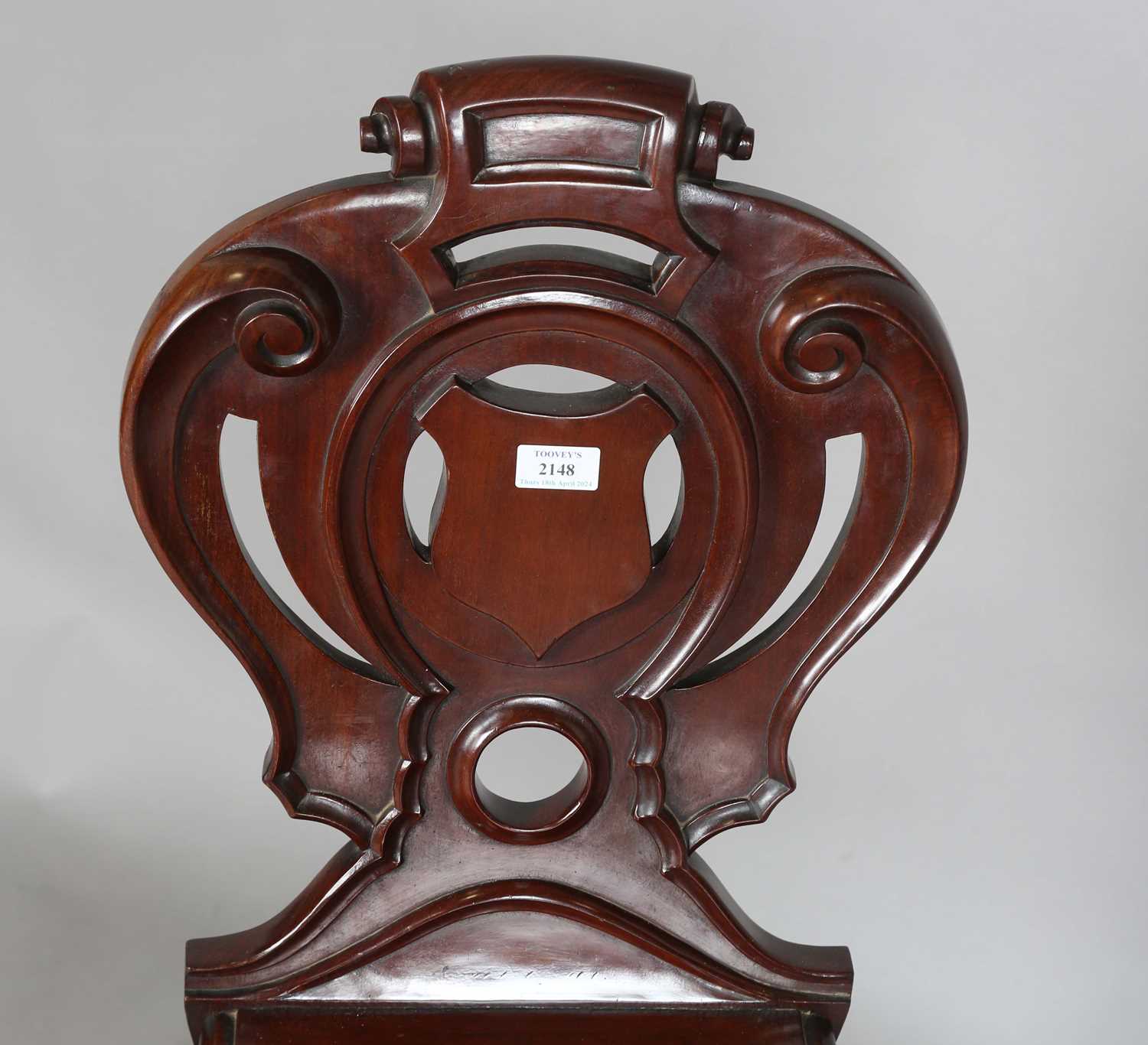 A mid-Victorian mahogany hall chair, the finely carved shield back above a solid seat, raised on - Image 2 of 8