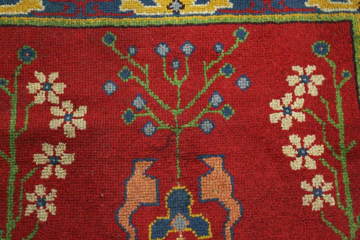 A Donegal Arts and Crafts rug, late 19th century, the red field with bold stylized plants, within - Image 3 of 6