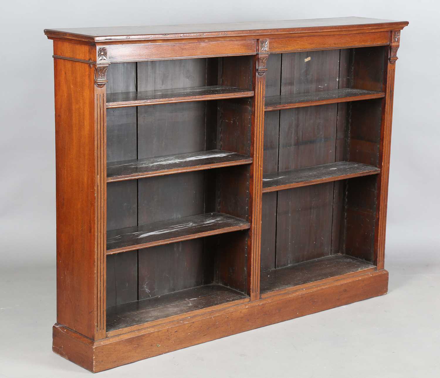 An Edwardian mahogany two-section open bookcase, on a plinth base, height 117cm, width 154cm,
