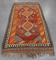 A Turkish kelhim rug, early 20th century, the shaded red field with two linked medallions, within