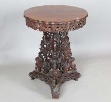 A 19th century Burmese hardwood centre table, the shaped circular top above a tripod support of