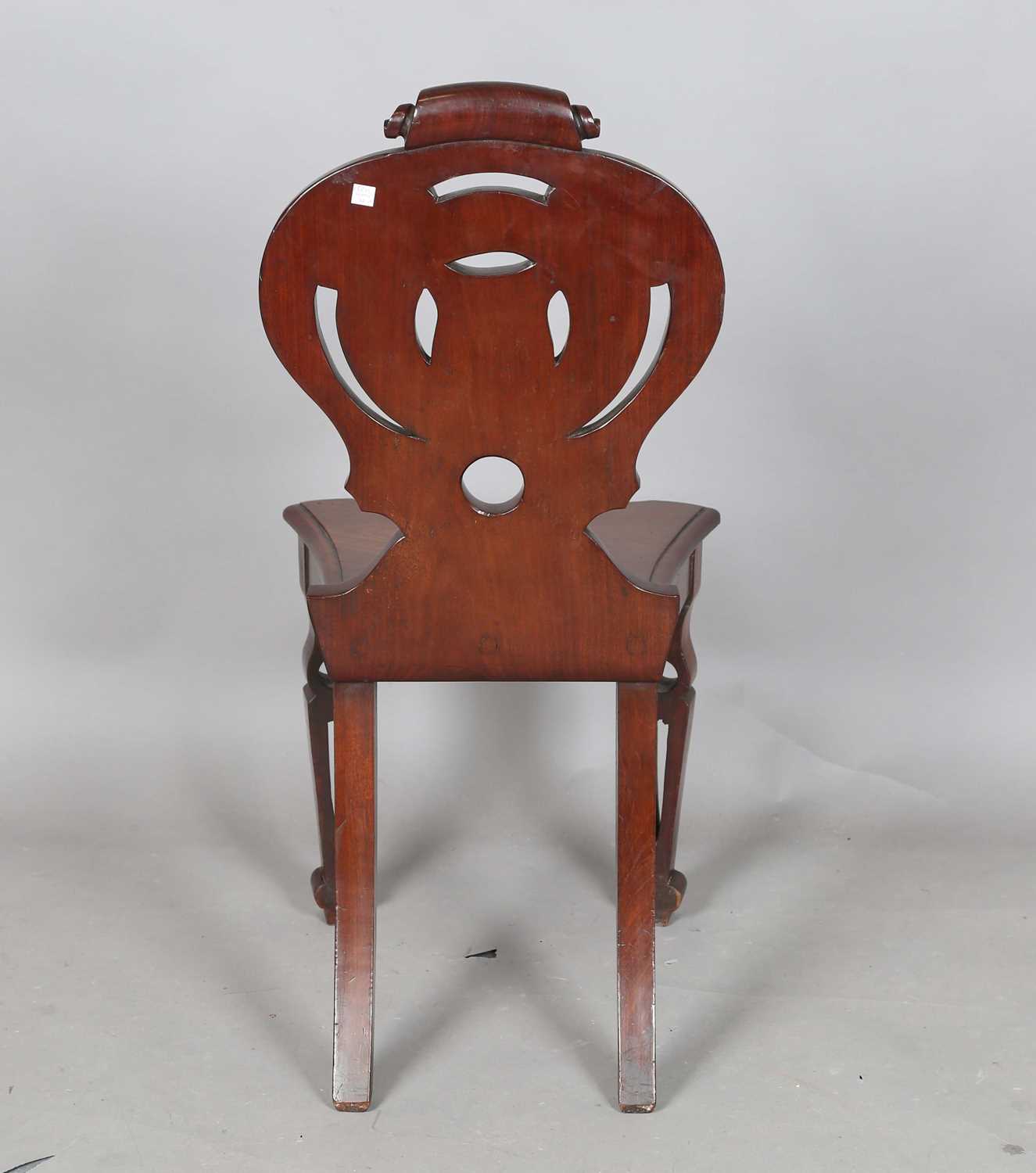 A mid-Victorian mahogany hall chair, the finely carved shield back above a solid seat, raised on - Image 6 of 8