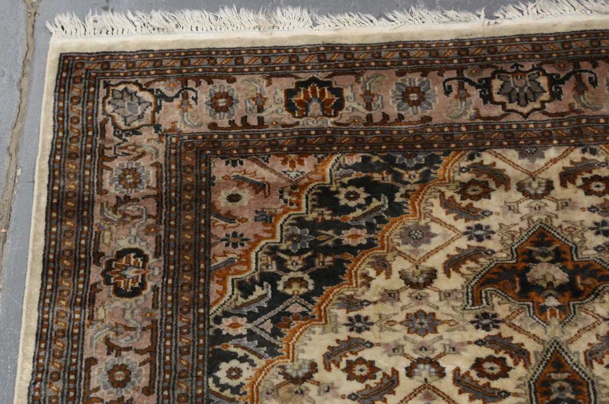 A Kashmir rug, signed, late 20th century, the cream field with a shaped medallion, within a palmette - Image 2 of 6