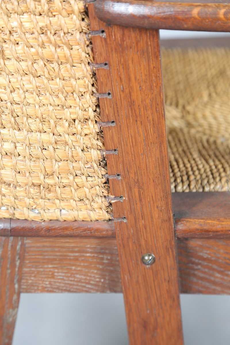 An early 20th century oak framed Orkney armchair, the curved woven straw back and string seat raised - Image 10 of 14