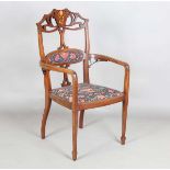 An Edwardian Art Nouveau mahogany framed elbow chair, the pierced back inlaid with a stylized flower