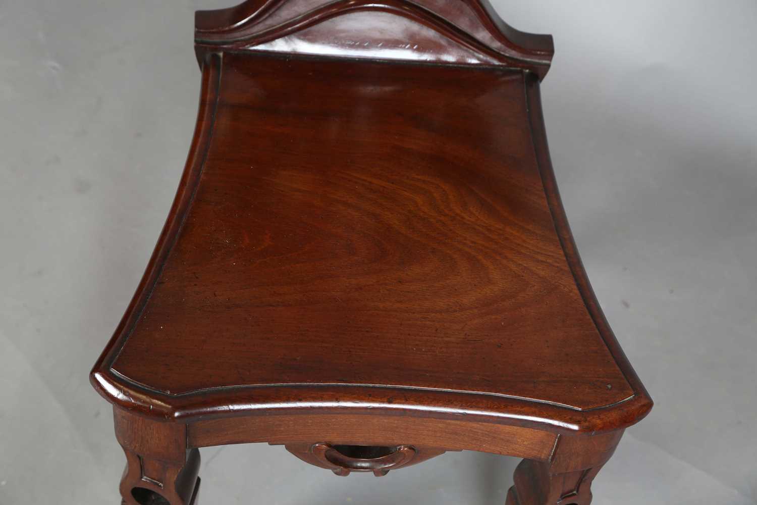 A mid-Victorian mahogany hall chair, the finely carved shield back above a solid seat, raised on - Image 3 of 8