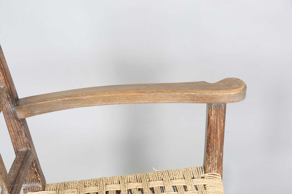 An early 20th century Cotswold School limed oak low elbow chair with woven string seat, height 70cm, - Image 7 of 10