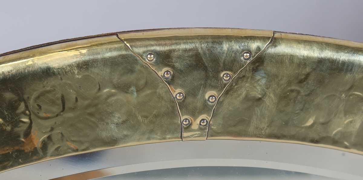 An early 20th century Arts and Crafts brass oval wall mirror with riveted panels and raised - Image 2 of 7