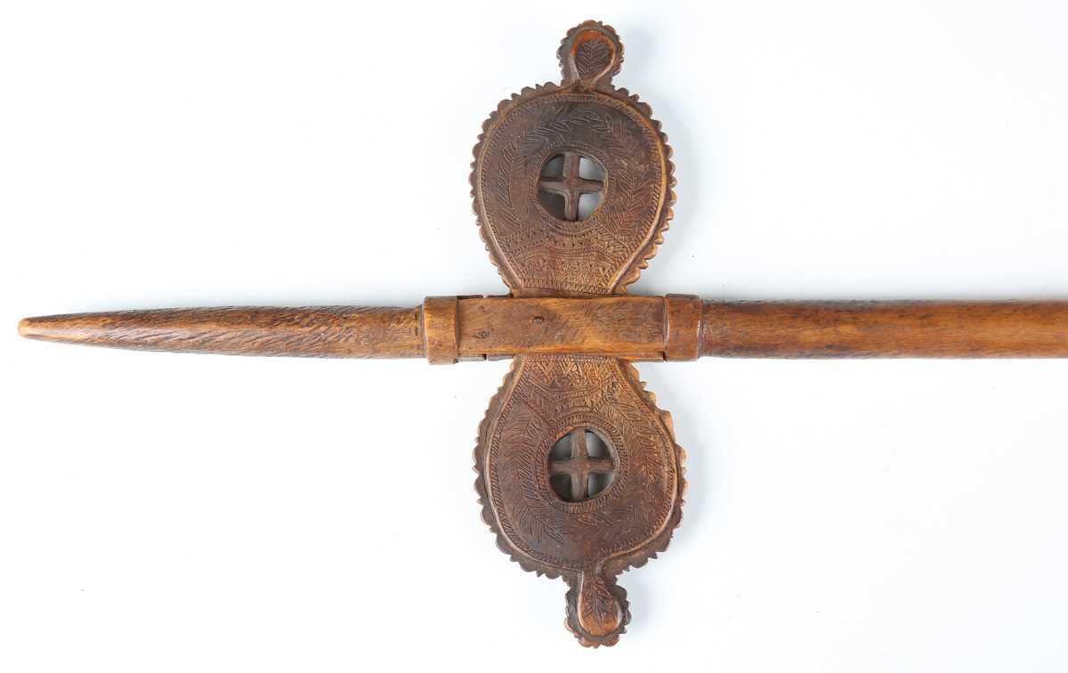 A 19th century patinated treen distaff, probably Greek, the shaped crosspiece finely incised with