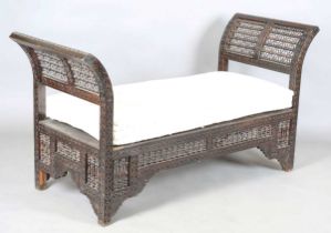 An early 20th century Middle Eastern softwood daybed, similar to those retailed by Liberty & Co,