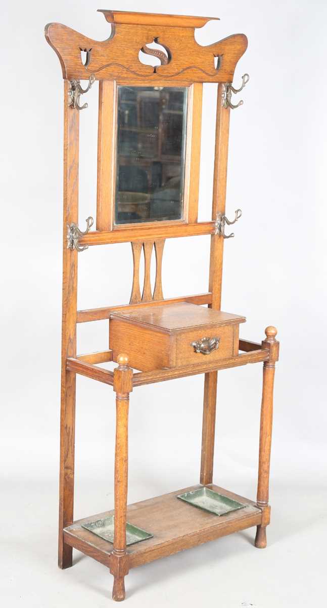 An Edwardian Arts and Crafts oak hallstand, the pediment pierced with stylized tulips, height