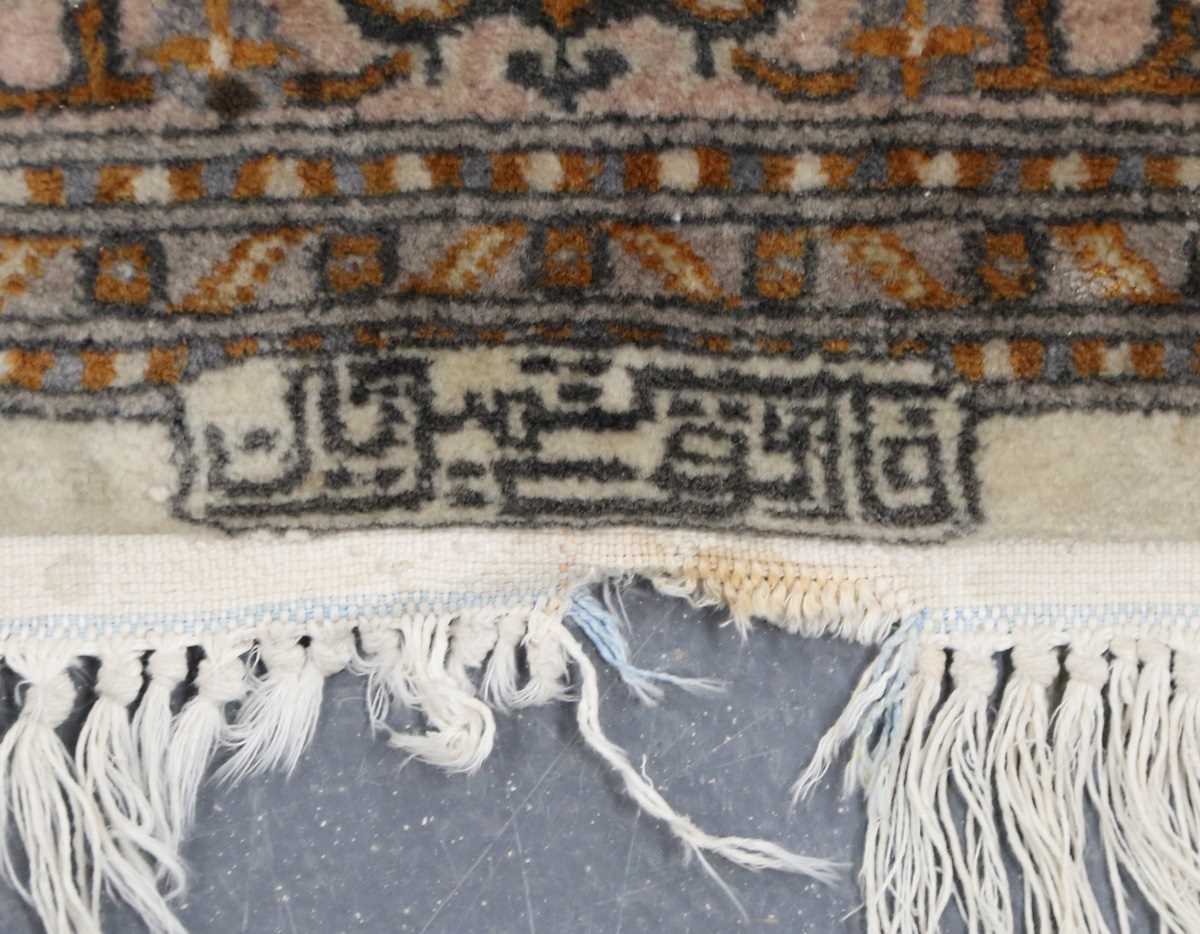 A Kashmir rug, signed, late 20th century, the cream field with a shaped medallion, within a palmette - Image 5 of 6