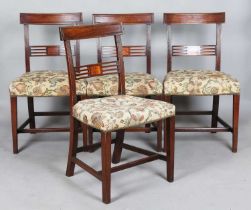 A set of four George IV mahogany bar back dining chairs with satinwood inlaid pierced centre