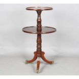 A 19th century mahogany circular two-tier dumb waiter, raised on tripod legs with brass caps and
