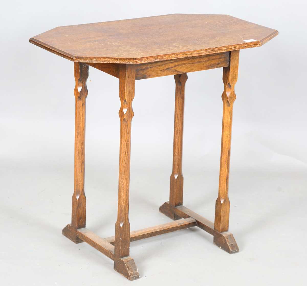 An early 20th century Arts and Crafts style oak canted rectangular occasional table, raised on