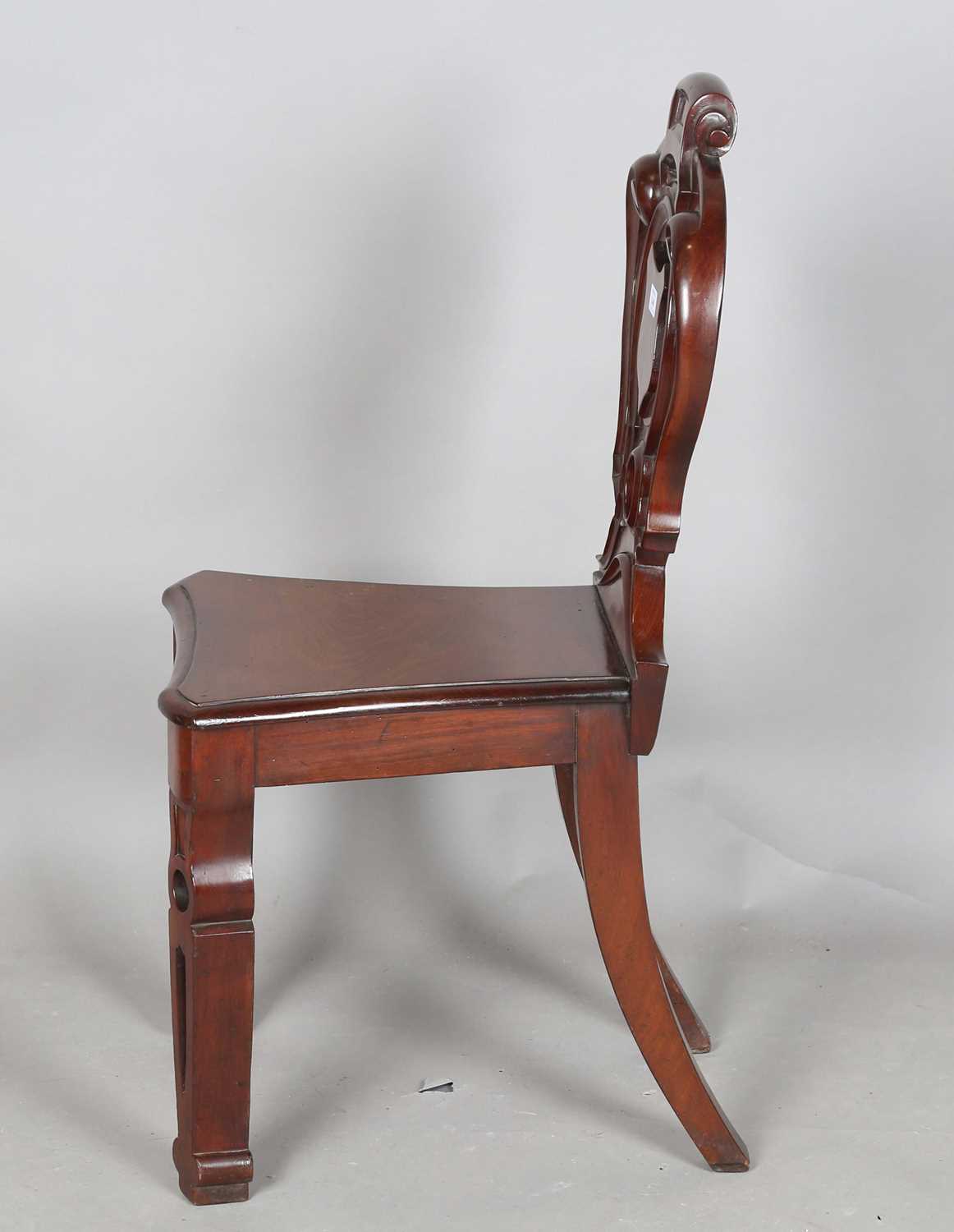 A mid-Victorian mahogany hall chair, the finely carved shield back above a solid seat, raised on - Image 7 of 8