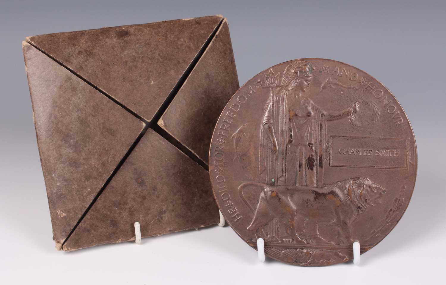 A First World War period bronze memorial plaque, detailed ‘Charles Smith’, with the original folding