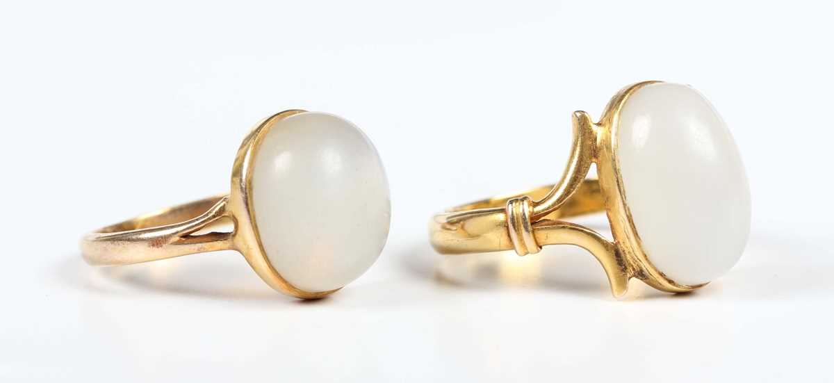 A gold ring collet set with a cabochon white hardstone, with split ‘V’ shaped shoulders, unmarked,