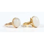 A gold ring collet set with a cabochon white hardstone, with split ‘V’ shaped shoulders, unmarked,