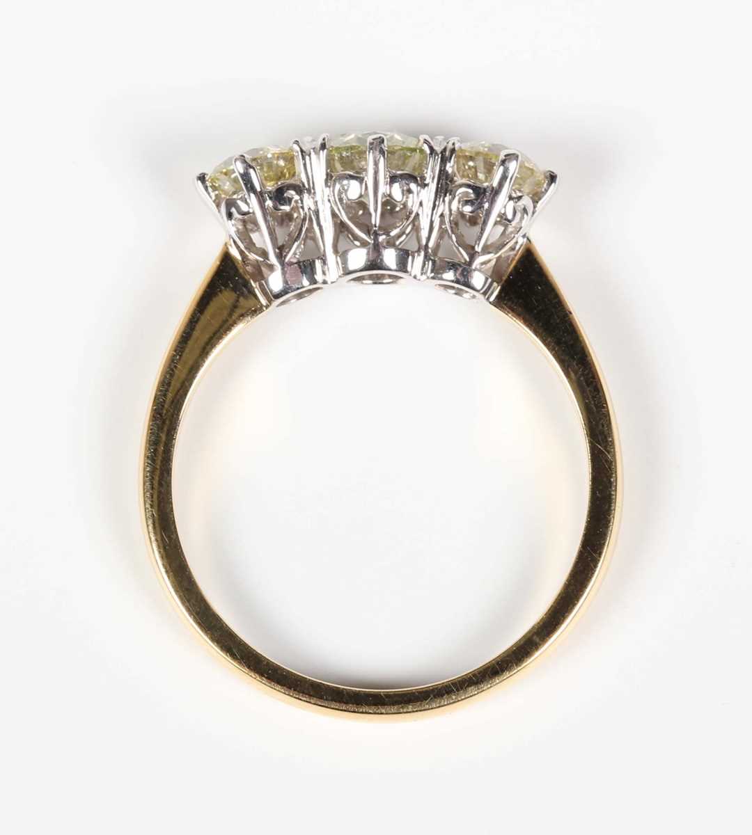 An 18ct gold and diamond three stone ring, claw set with a row of circular cut diamonds, weight 3. - Image 4 of 6