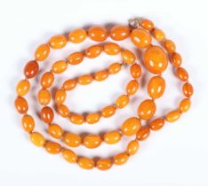A single row necklace of fifty-five graduated oval opaque and semitranslucent mottled butterscotch