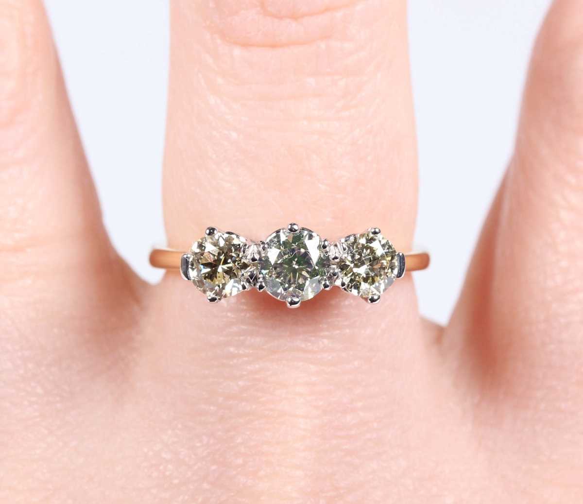 An 18ct gold and diamond three stone ring, claw set with a row of circular cut diamonds, weight 3. - Image 5 of 6