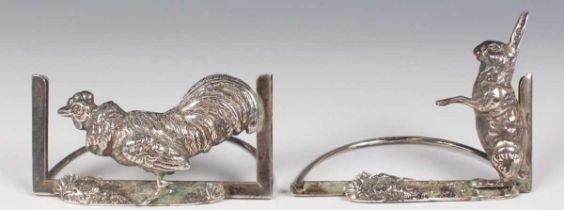 A pair of Edwardian silver novelty menu holders, each front embossed with a figure of a rabbit or