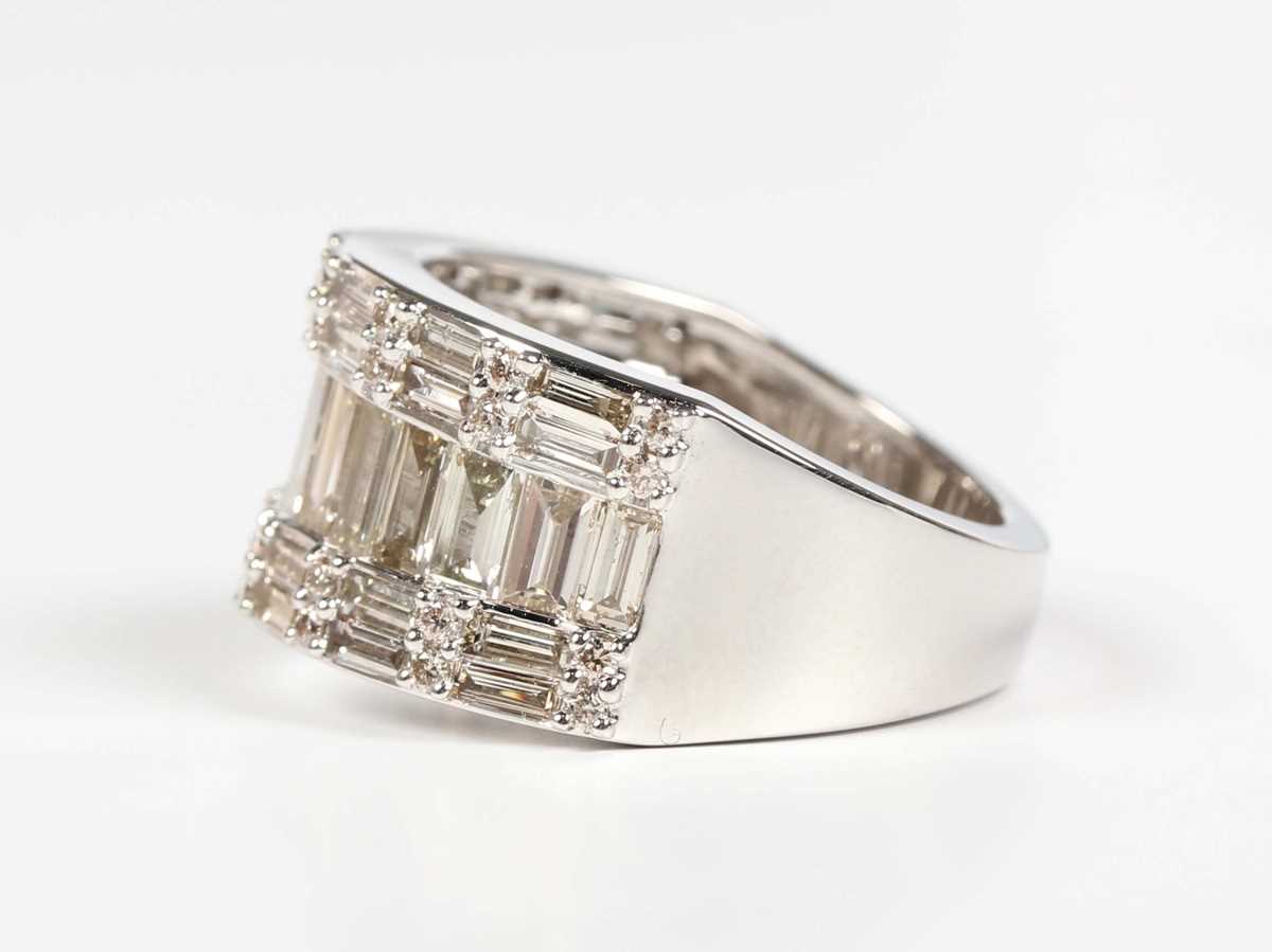 A platinum and diamond ring, mounted with a row of graduated baguette cut diamonds between rows of - Image 3 of 5