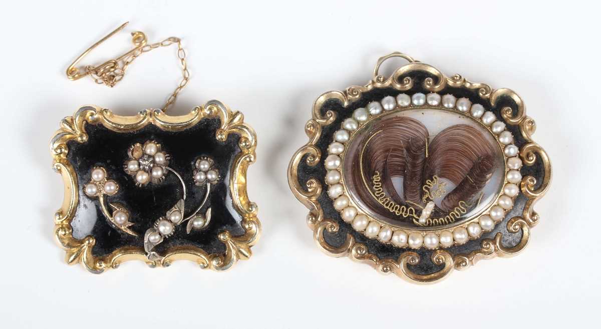 A black enamelled and half-pearl shaped oval mourning brooch, mid-19th century, glazed to the centre