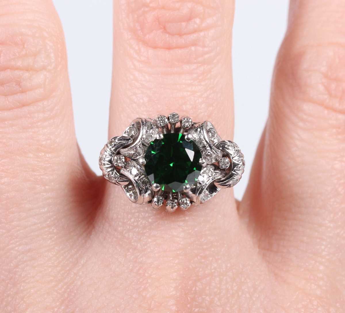 A platinum, demantoid garnet and diamond ring, claw set with the circular cut green demantoid garnet - Image 5 of 5
