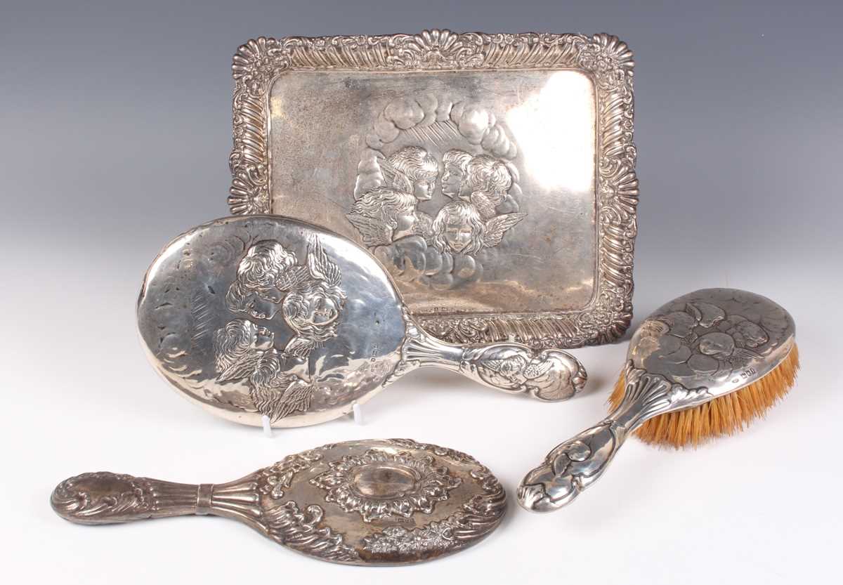 An Edwardian silver rectangular dressing table tray, embossed with amorini within a reeded and