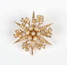 A 15ct gold and seed pearl starburst pendant brooch with foliate motifs at intervals, detailed ‘15’,