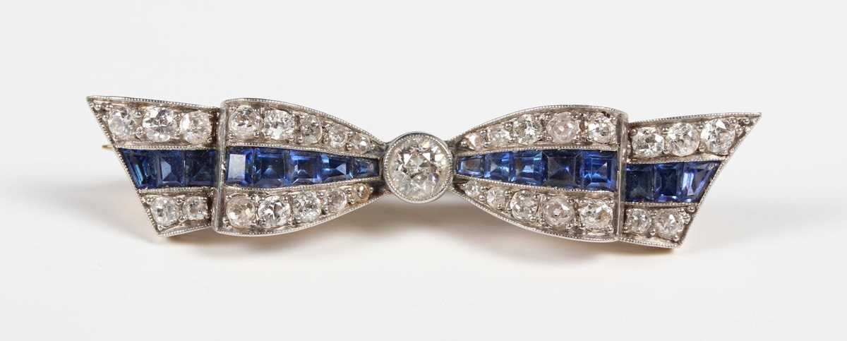 A gold backed and platinum fronted, sapphire and diamond brooch designed as a tied bow, collet set