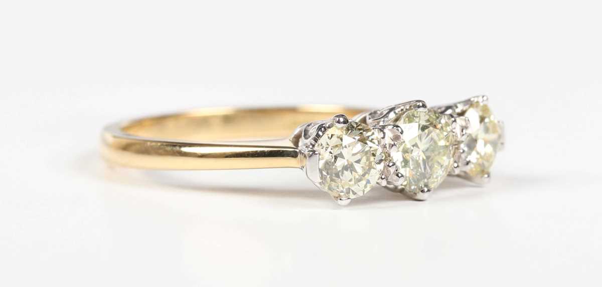 An 18ct gold and diamond three stone ring, claw set with a row of circular cut diamonds, weight 3.