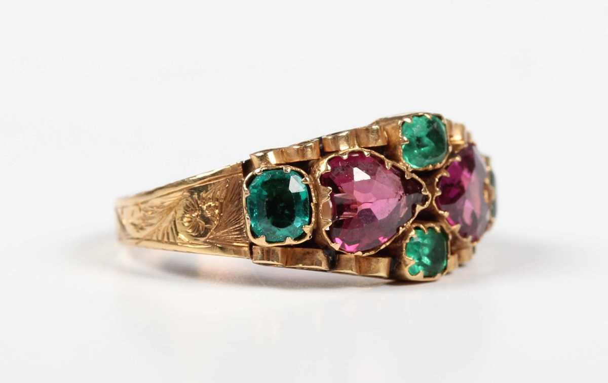 A 12ct gold, garnet, emerald and green gem set ring, mounted with two heart shaped garnets to the