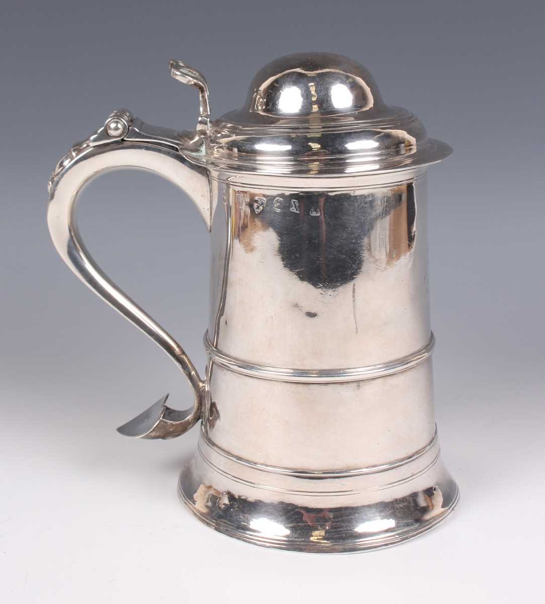 A George III silver tankard of tapering cylindrical girdled form, the domed hinged lid and pierced