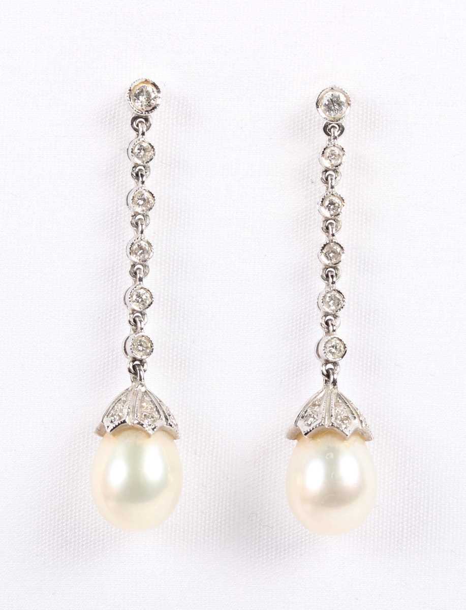 A pair of white gold, diamond and cultured pearl pendant earrings, each mounted with a drop shaped