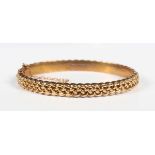 A late Victorian 9ct gold oval hinged bangle in an interwoven design, on a snap clasp, Birmingham