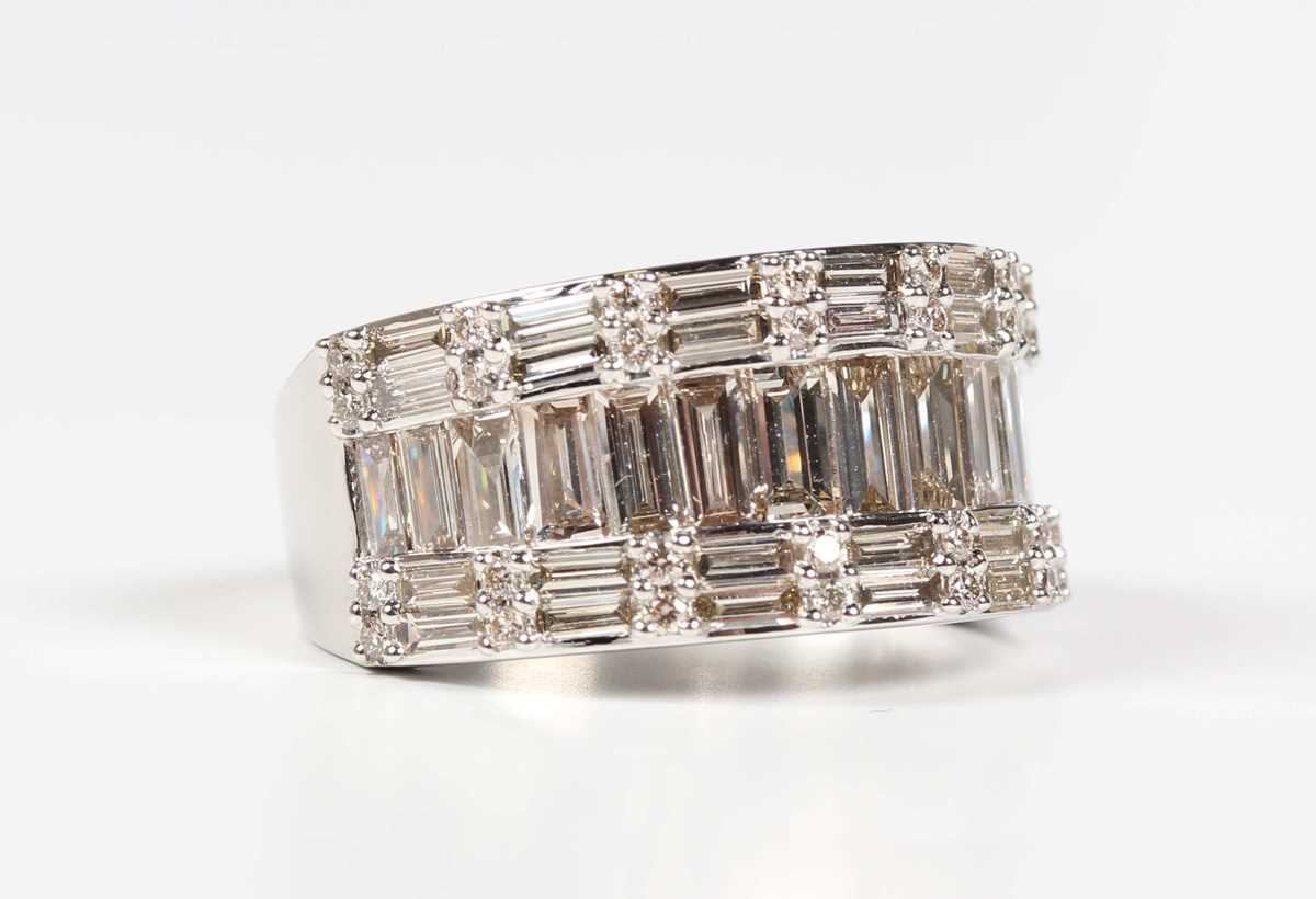 A platinum and diamond ring, mounted with a row of graduated baguette cut diamonds between rows of
