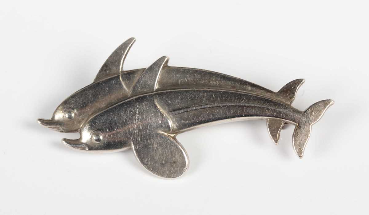 A Georg Jensen sterling silver brooch, designed as two dolphins, detailed ‘Georg Jensen Sterling