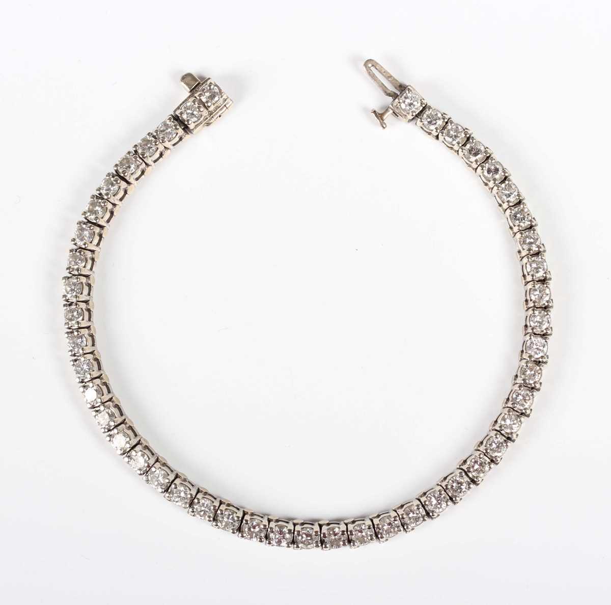 A diamond line bracelet, claw set with a row of circular cut diamonds, on a snap clasp with a