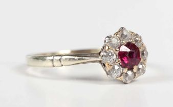 A gold, ruby and diamond cluster ring, claw set with the cushion cut ruby within a surround of eight