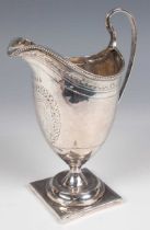 A George III silver helmet cream jug with bright-cut engraved decoration and beaded rim, on a