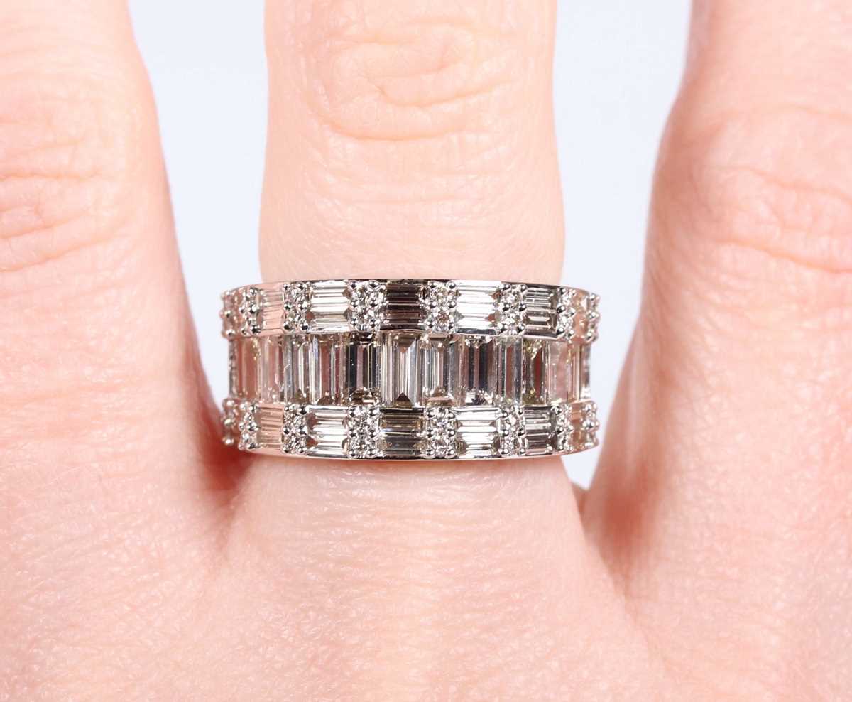 A platinum and diamond ring, mounted with a row of graduated baguette cut diamonds between rows of - Image 5 of 5