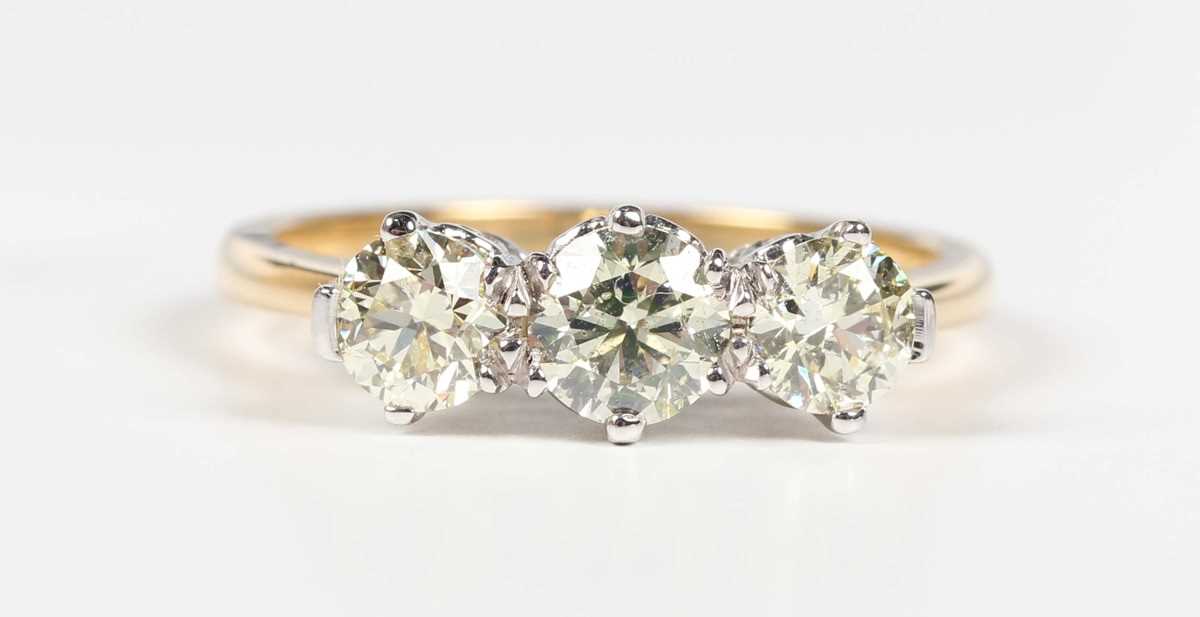 An 18ct gold and diamond three stone ring, claw set with a row of circular cut diamonds, weight 3. - Image 2 of 6