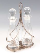 An Elizabeth II silver oil and vinegar bottle stand with wirework sides and central ring handle,