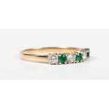 A gold, emerald and diamond ring, claw set with three circular cut emeralds alternating with four