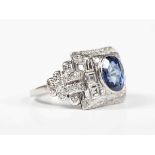 A platinum, sapphire and diamond ring in an Art Deco inspired design, collet set with the oval cut